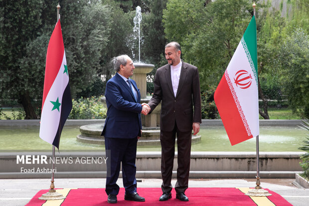 حسین امیر عبدالهییان وزیر امور خارجه ایران و  فیصل مقداد وزیر خارجه سوریه در حال گرفتن عکس یادگاری در محل دیدار وزرای خارجه سوریه و ایران هستند 