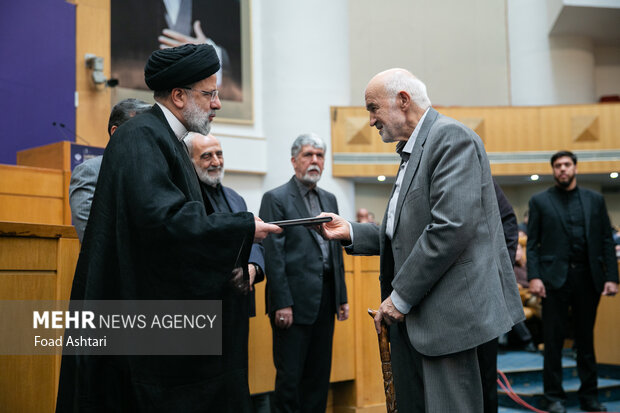 حجت الاسلام سید ابراهیم رئیسی ، رئیس جمهور 
در حال تقدیر از احمد توکلی در مراسم اختتامیه بیست و یکمین جشنواره ملی رسانه های ایران است 