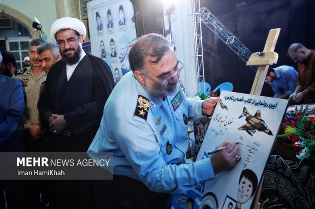 امیر واحدی فرمانده کل نیروی هوایی ارتش در حال امضای کتاب شهید نوژه آیین میهمان ملائک در همدان