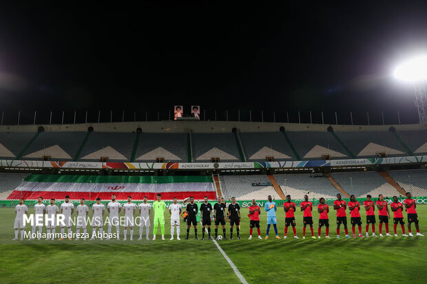 تیم های ملی فوتبال ایران و آنگولا در حال انجام تشریفات پیش از آغاز مسابقه در ورزشگاه آزادی تهران هستند