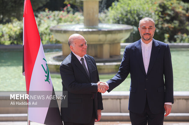 حسین امیر عبداللهیان، وزیر امور خارجه ایران و  فواد حسین، وزیر امور خارجه عراق در حال گرفتن عکس یادگاری هستند