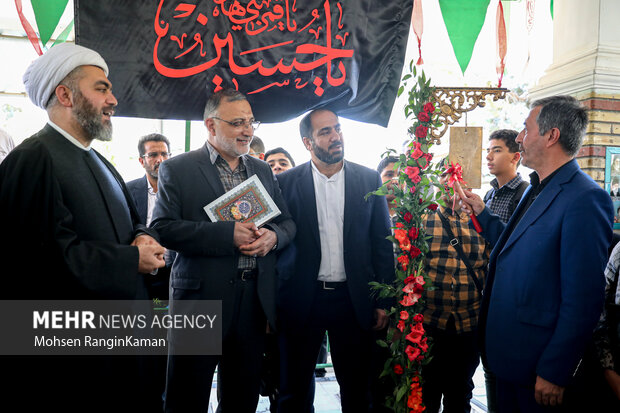 پدر شهید آرمان علی‌وردی در حال نواختن زنگ دانش‌آموز شهید است