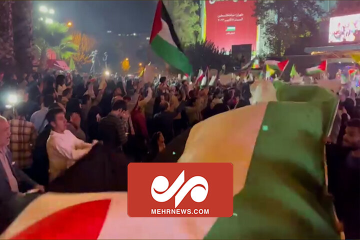 پرچم فلسطین روی دستان مردم به همراه آتش بازی میدان فلسطین