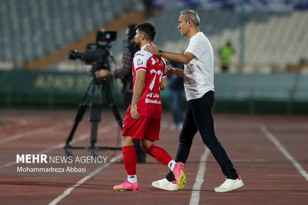 یحیی گلمحمدی سرمربی تیم فوتبال پرسپولیس تهران در حال گفتگو با محمد عمری پیش از تعویض در دیدار تیم های فوتبال پرسپولیس تهران و گل گهر سیرجان است