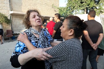 Women react outside St. Porphyrios Greek Orthodox Church in Gaza Oct. 20, 2023, after an explosion went off the night before. Several hundred people had been sheltering at the church complex, many of them sleeping, at the time of the explosion.