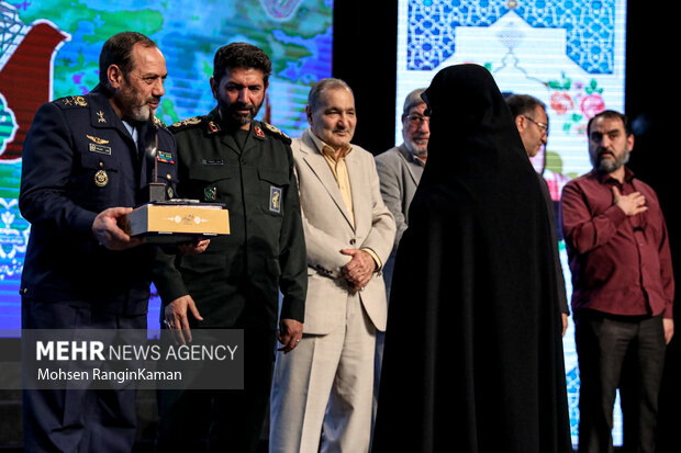 امیر سرتیپ عزیز نصیرزاده جانشین رئیس ستاد کل نیروهای مسلح در حال تقدیر از خانواده معظم شهدا در دومین یادواره شهدای فرهنگی شهر تهران است