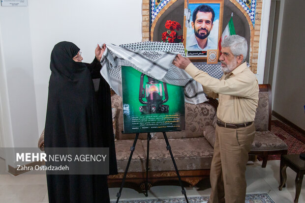 پدر و مادر شهید مصطفی احمدی روشن در حال رونمایی از پوستر چهاردهمین جشنواره مردمی فیلم عمار  هستند