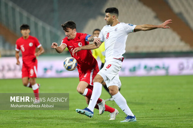 مهدی طارمی مهاجم تیم ملی فوتبال ایران در حال عبور توپ از مدافعین تیم ملی فوتبال هنگ کنگ در دیدار تیم های ملی فوتبال ایران و هنگ کنگ است