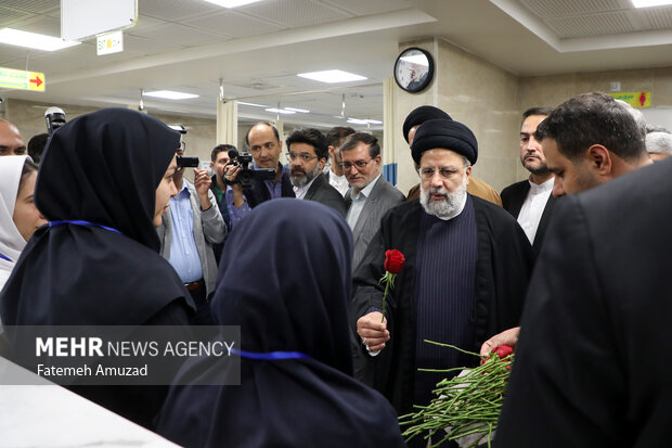 حجت الاسلام سید ابراهیم رئیسی، رئیس جمهور در حال  اهدای شاخه گل به پرستاران بیمارستان امام خمینی (ره) شهریار به مناسبت روز پرستار است 