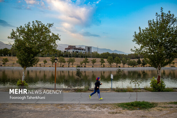 الهام حسینی در کنار دریاچه آزادی در حال انجام تمرینات هوازی است