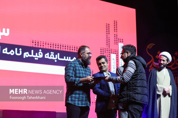 عباس قدیر محسنی نویسنده کودک و نوجوان در حال دریافت تقدیرنامه در مراسم اختتامیه پنجاه و سومین جشنواره بین المللی فیلم رشداست