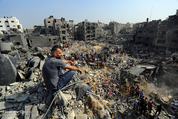 A man sits on rubble as others search among the debris of buildings targeted by Israeli air strikes in Jabaliya refugee camp, the northern Gaza Strip, on November 1. [Abed Khaled/AP Photo]
