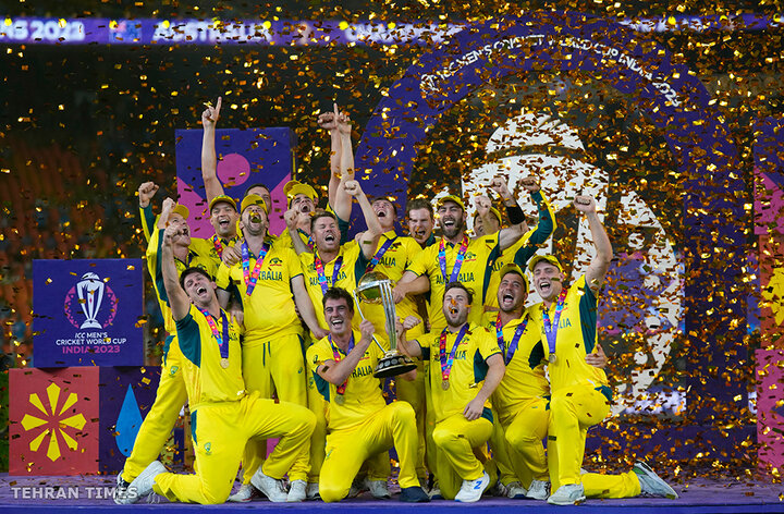 Australian players celebrate with the trophy after beating India during the ICC Men's Cricket World Cup final match in Ahmedabad, India, on November 19. [Aijaz Rahi/AP Photo]
