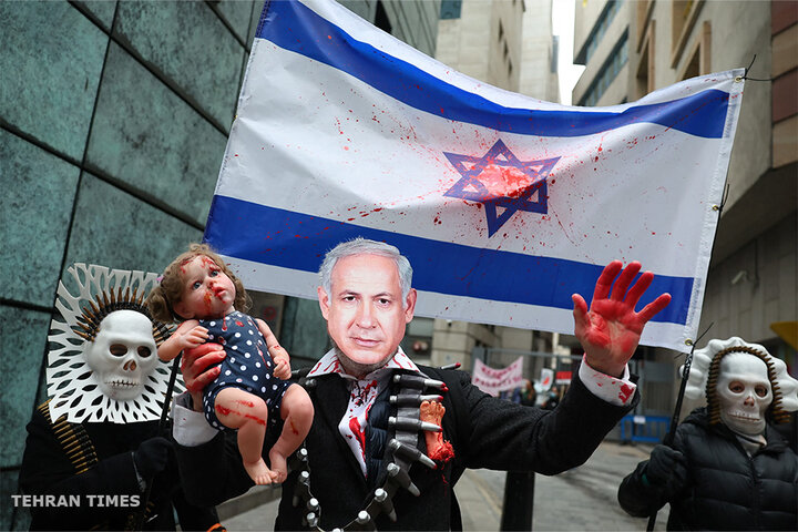 A person wearing a mask depicting Israeli Prime Minister Benjamin Netanyahu holds a doll as people take part in a protest in London, UK, to mark 100 days since the start of the war on Gaza [Toby Melville/Reuters]
