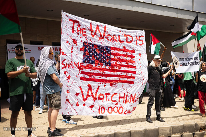 Protesters carry placards during a free Palestine protest at the United States Consulate, in Johannesburg, South Africa. [Kim Ludbrook/EPA]
