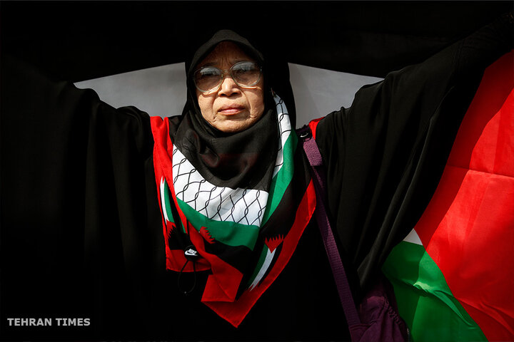 A Thai-Muslim demonstrator holds a large Palestinian flag during a protest calling for a permanent ceasefire in Gaza, at the US embassy in Bangkok, Thailand. [Rungroj Yongrit/EPA]
