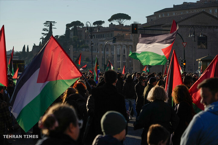 People wave Palestinian flags during a rally in Rome. [Gregorio Borgia/AP Photo]
