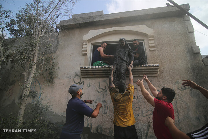 Palestinians evacuate a building hit in the Israeli bombardment in Rafah in southern Gaza. [Hatem Ali/AP Photo]
