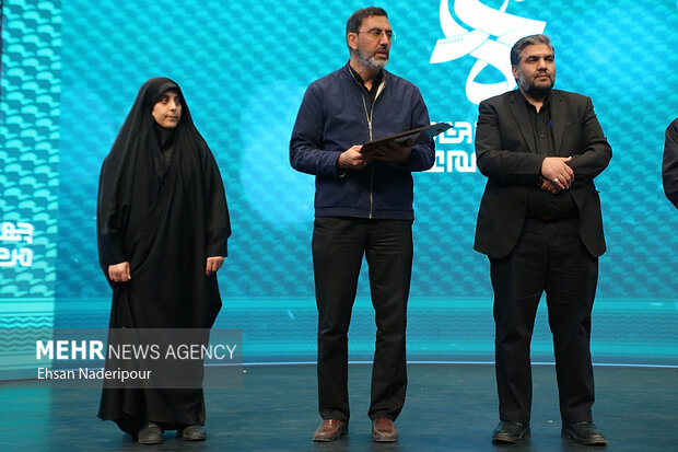 خانواده شهیده فائزه رحیمی دانشجو معلم و از شهدای حادثه تروریستی کرمان و پیمان سلطانی نژاد همسر شهیده فاطمه سلطانی نژاد و پدر شهید محمدامین سلطانی نژاد و شهیده ریحانه سلطانی نژاد ملقب به دختر کاپشن صورتی (راست) با گوشواره قلبی در مراسم اختتامیه جشنواره فیلم عمار حضور دارند
