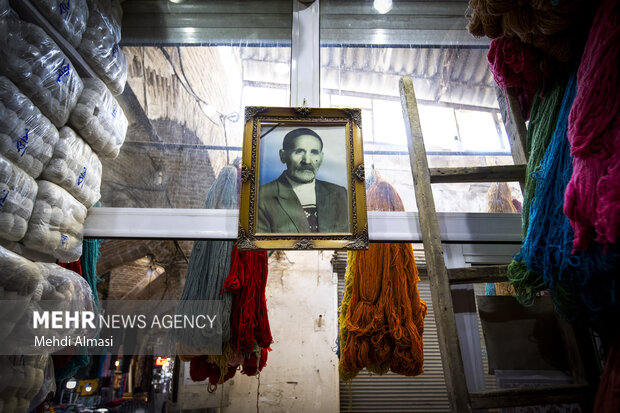 عکسی از یک پدر که در گوشه ای از مغازه قدیمی رنگرزی جای گرفته