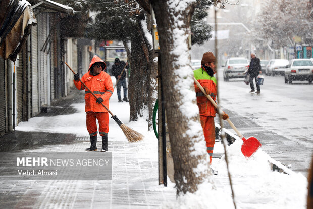 کارگران شهرداری درحال تمیز کردن پیاده رو