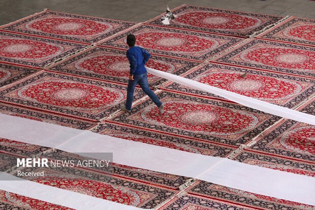 تلاش خادمان برای برپایی سفره افطار در حرم بانوی کرامت