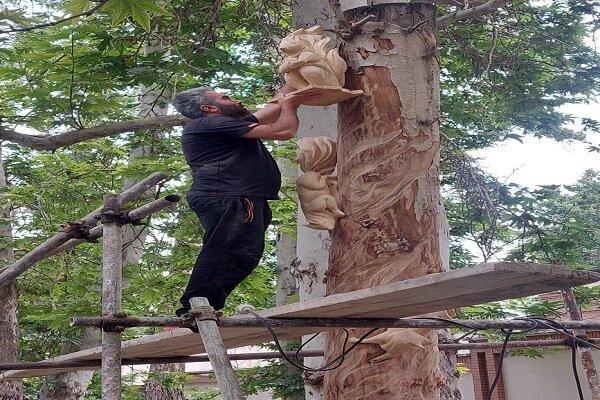 نقش آفرینی بر تنه درختان خشک باغ فردوس در آستانه غدیر