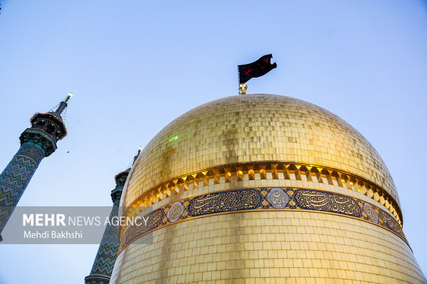 اهتزاز پرچم عزای حسینی بر فراز گنبد حرم بانوی کرامت