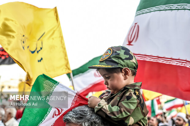 کودکی در تشییع فرماندهان نظامی با لباس مقدس ارتش در مراسم حضور دارد