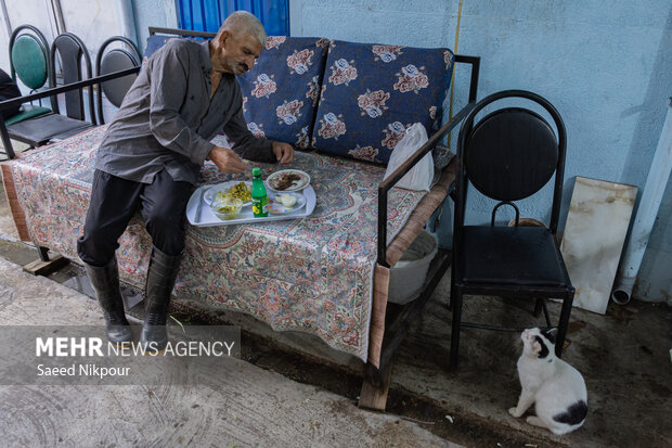 او در یک رستوران محلی در حال خوردن ناهار است، محبوب ترین غذای او باقلی خورشت با ماهی شور است.