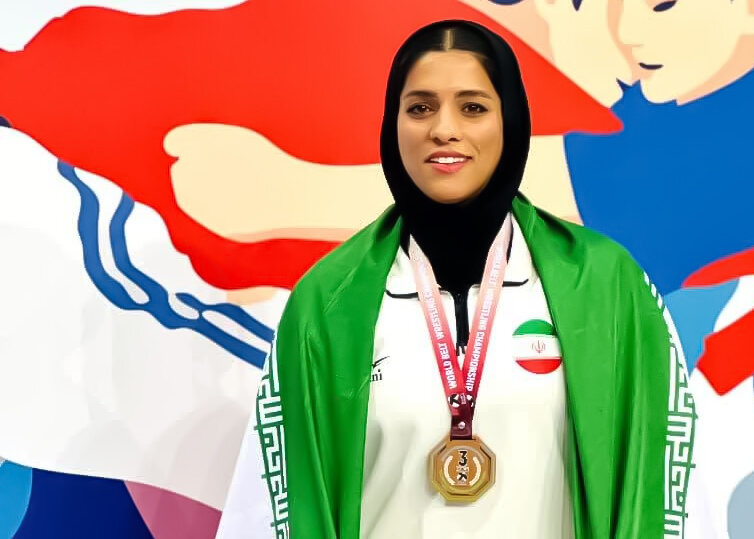 بانوی قمی در آوردگاه جهانی بر سکوی سوم کشتی با کمربند ایستاد