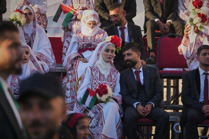 Palestinians celebrate as young couples attend mass wedding