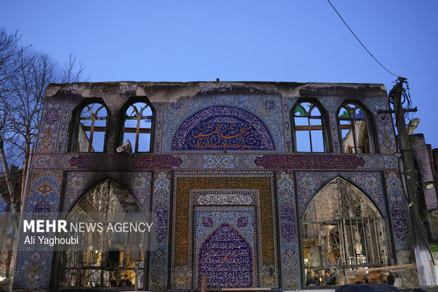 Performing prayers at burnt Hojjatieh Mosque in Rasht

