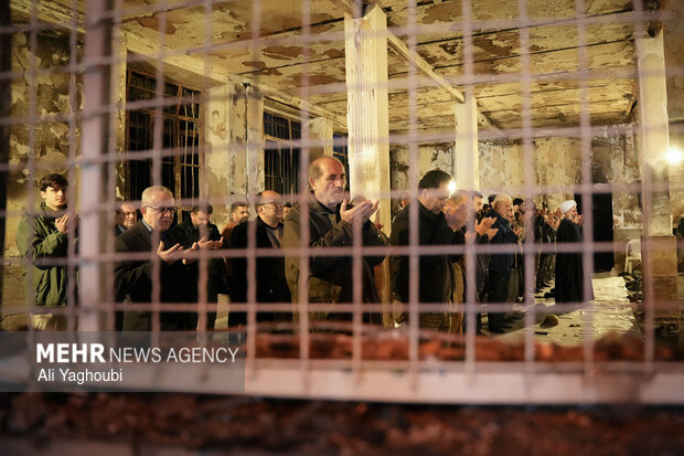 Performing prayers at burnt Hojjatieh Mosque in Rasht
