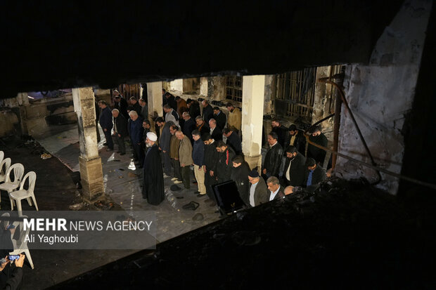 Performing prayers at burnt Hojjatieh Mosque in Rasht
