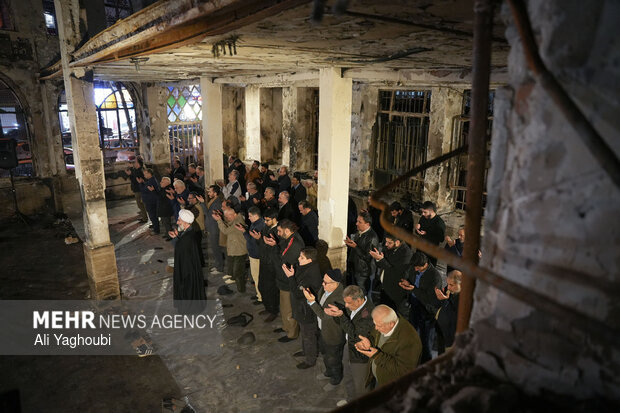 Performing prayers at burnt Hojjatieh Mosque in Rasht
