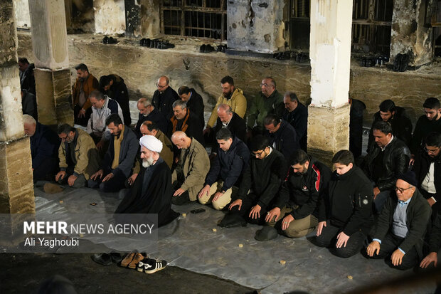 Performing prayers at burnt Hojjatieh Mosque in Rasht
