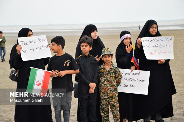 تشکیل زنجیره انسانی و آتش زدن نمادین تابوت سربازان آمریکایی در ساحل خلیج فارس