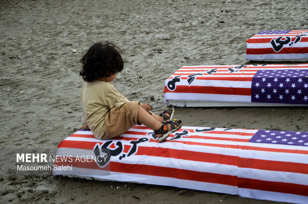 تشکیل زنجیره انسانی و آتش زدن نمادین تابوت سربازان آمریکایی در ساحل خلیج فارس