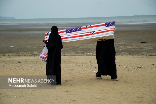 تشکیل زنجیره انسانی و آتش زدن نمادین تابوت سربازان آمریکایی در ساحل خلیج فارس