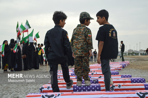 تشکیل زنجیره انسانی و آتش زدن نمادین تابوت سربازان آمریکایی در ساحل خلیج فارس