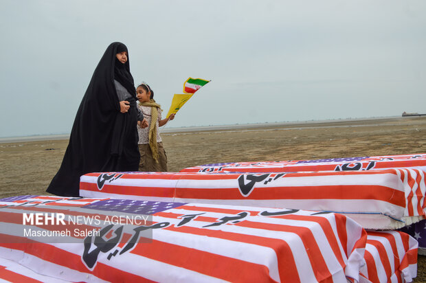 تشکیل زنجیره انسانی و آتش زدن نمادین تابوت سربازان آمریکایی در ساحل خلیج فارس