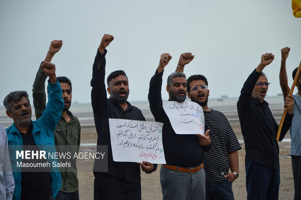 تشکیل زنجیره انسانی و آتش زدن نمادین تابوت سربازان آمریکایی در ساحل خلیج فارس