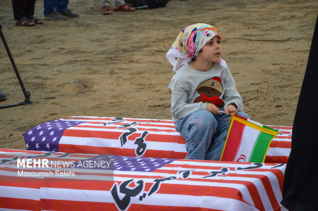 تشکیل زنجیره انسانی و آتش زدن نمادین تابوت سربازان آمریکایی در ساحل خلیج فارس