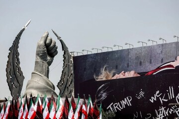A statue symbolising the hand of Iran’s late Supreme Leader Ayatollah Seyyed Ali Khamenei next to a billboard depicting Trump laid in a coffin, in Tehran, Iran, July 23, 2026.